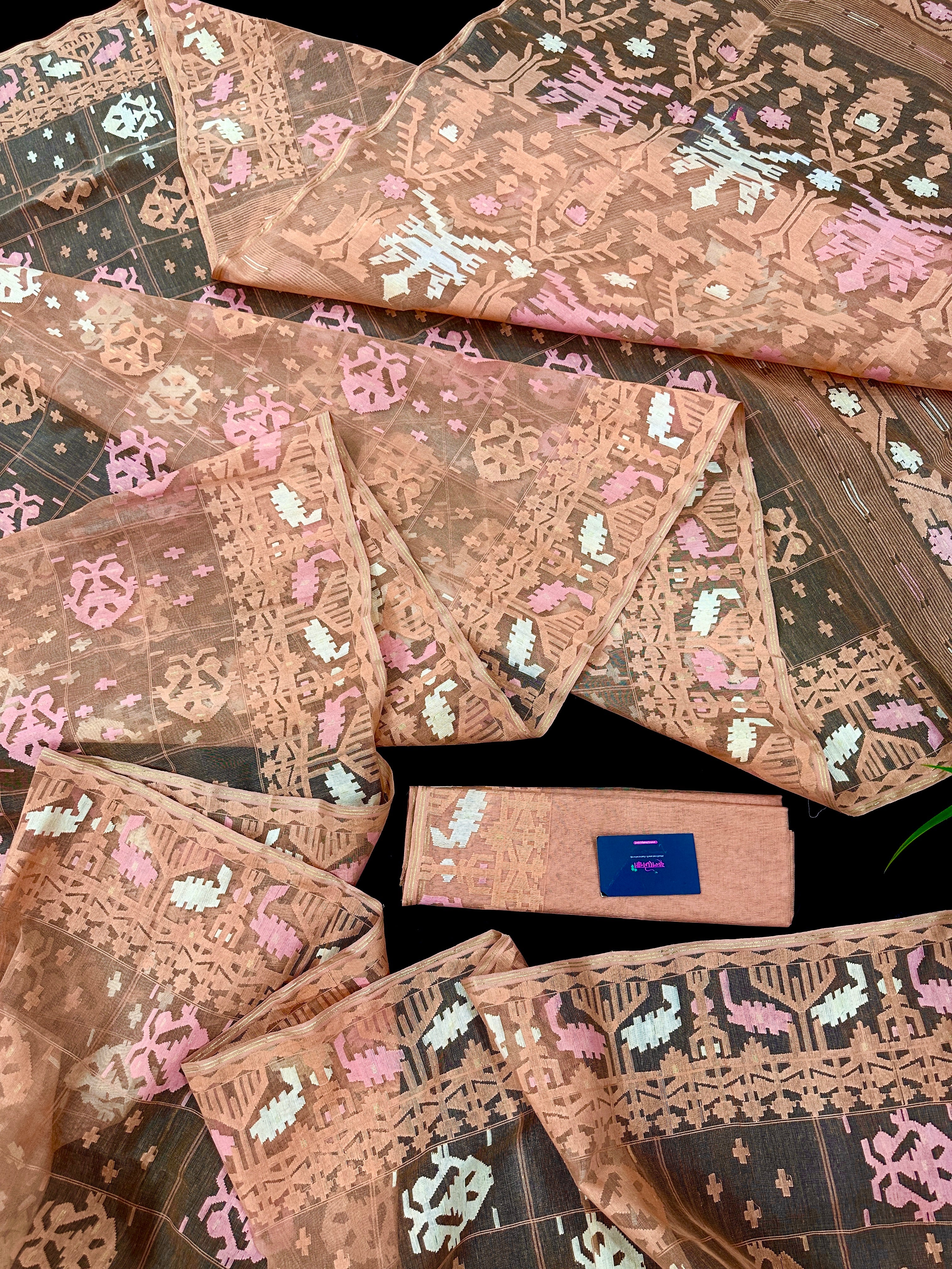 Creamy peach jamdani saree with pink white and peach threads work.