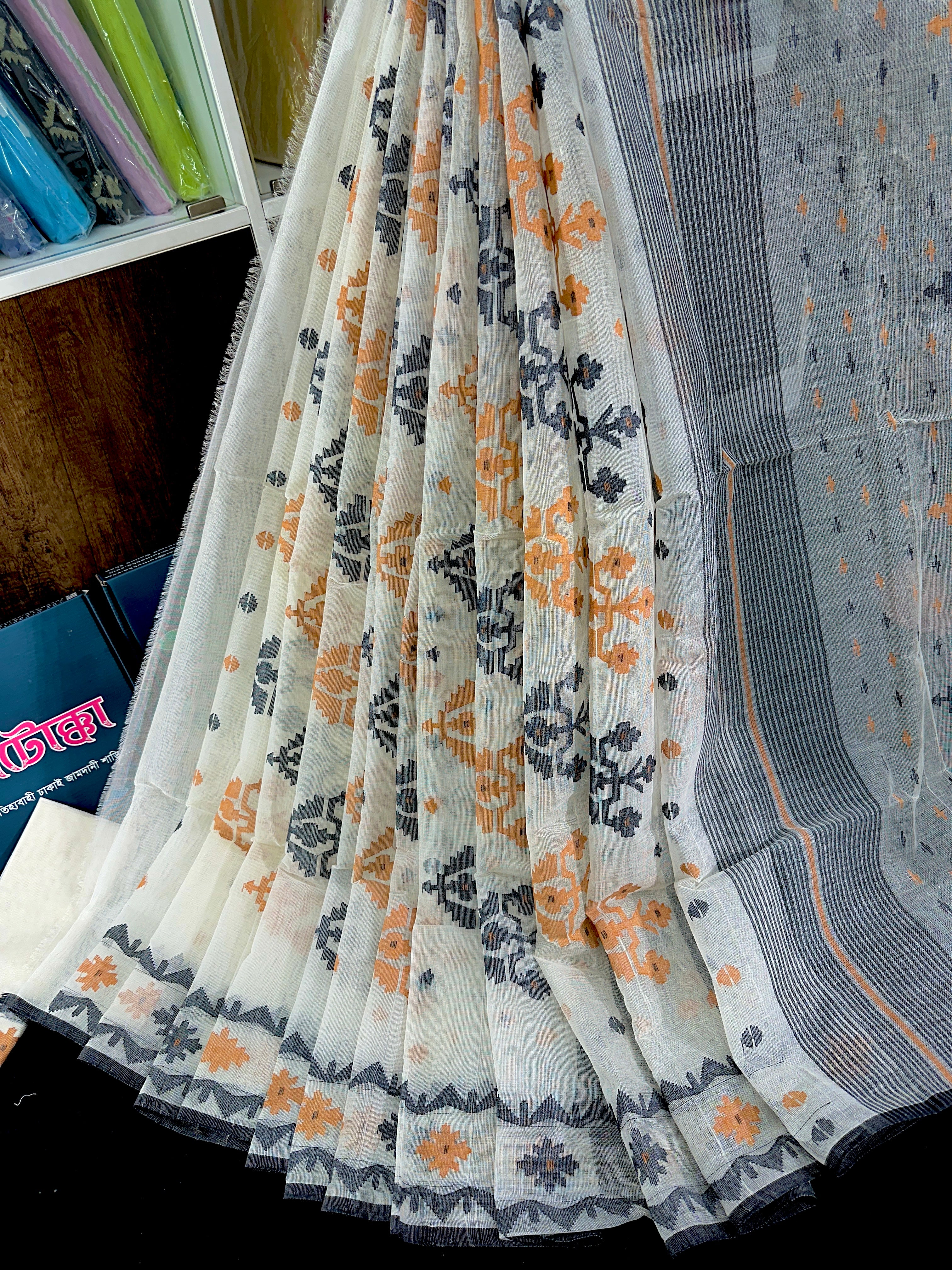 White cotton jamdani saree with orange black floral threads work