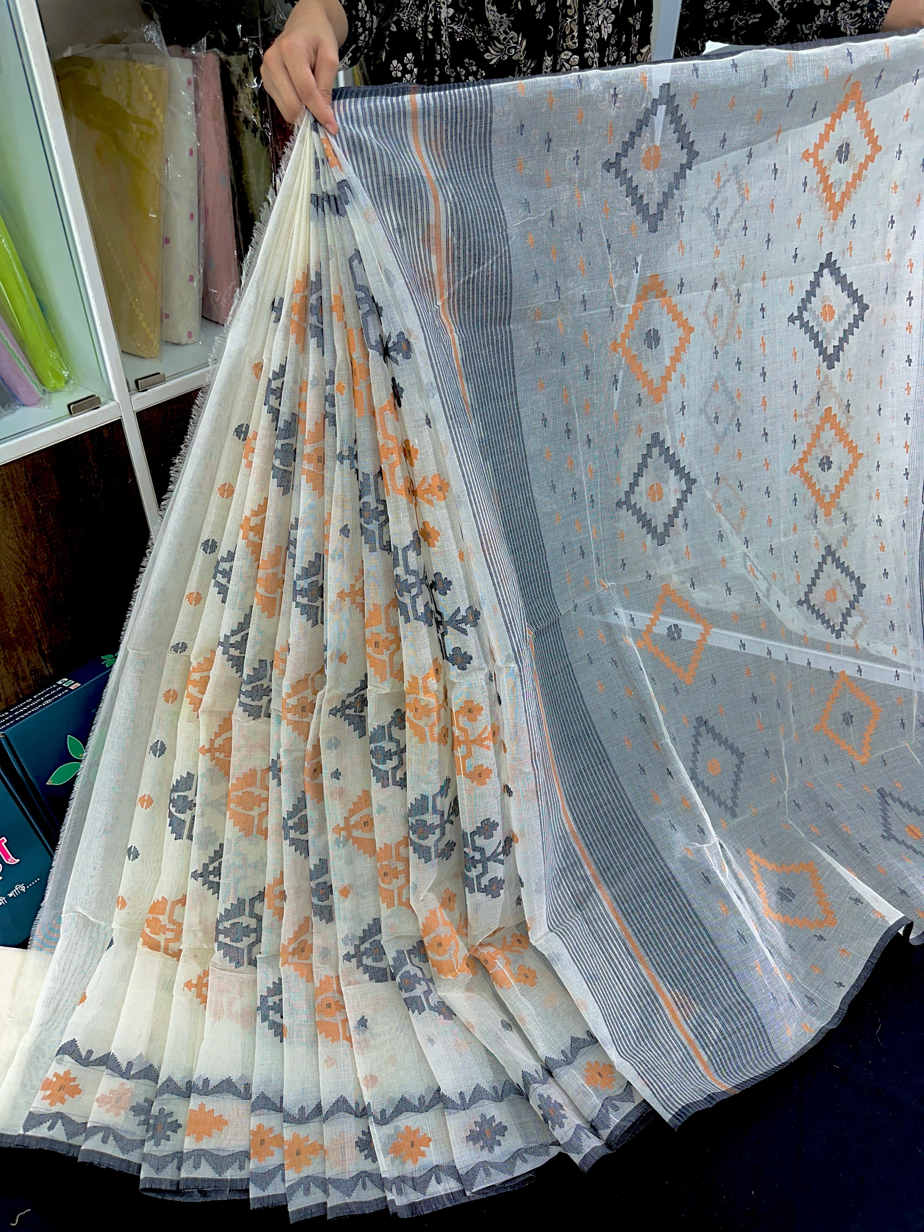 White cotton jamdani saree with orange black floral threads work