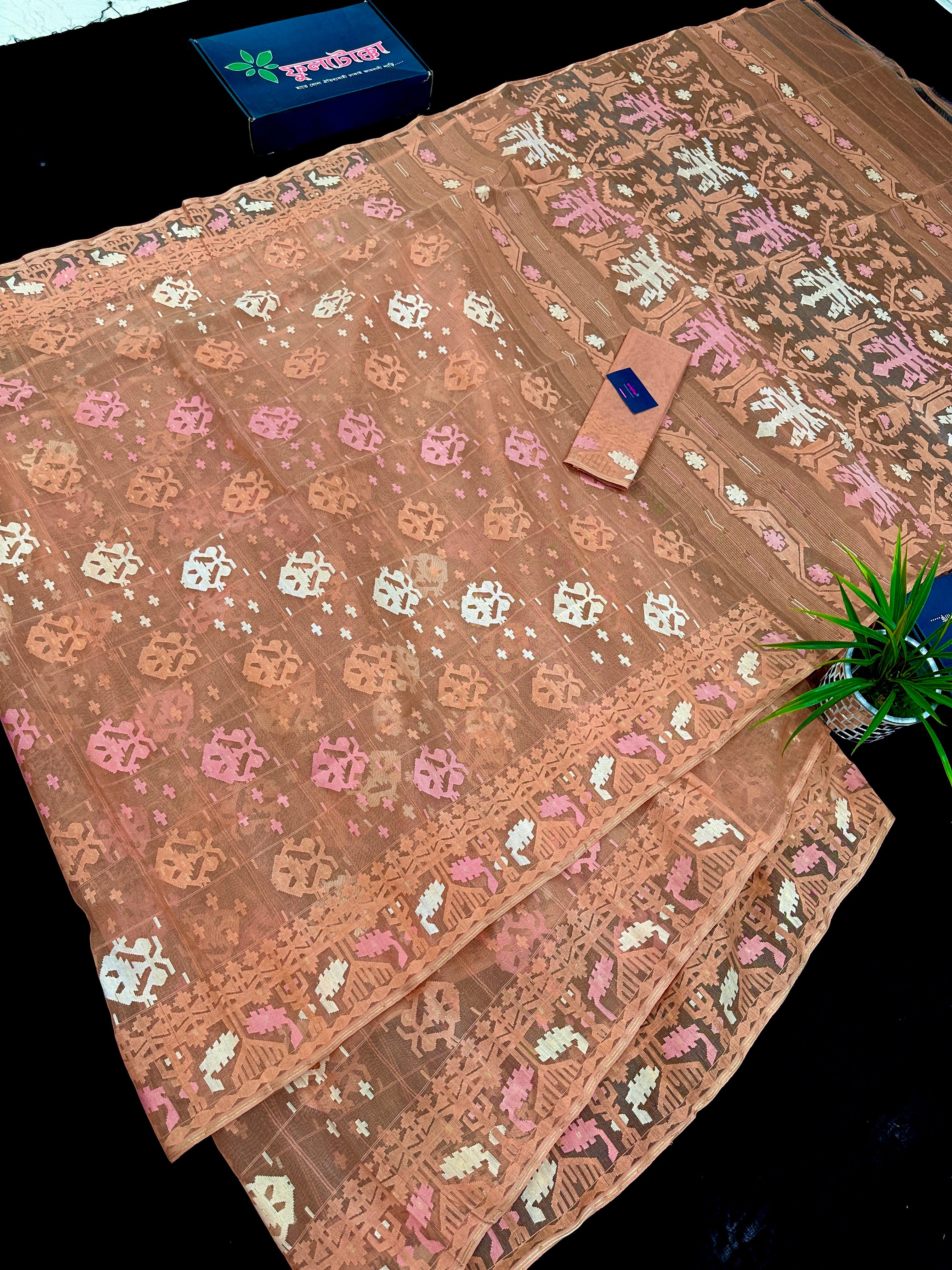 Creamy peach jamdani saree with pink white and peach threads work.