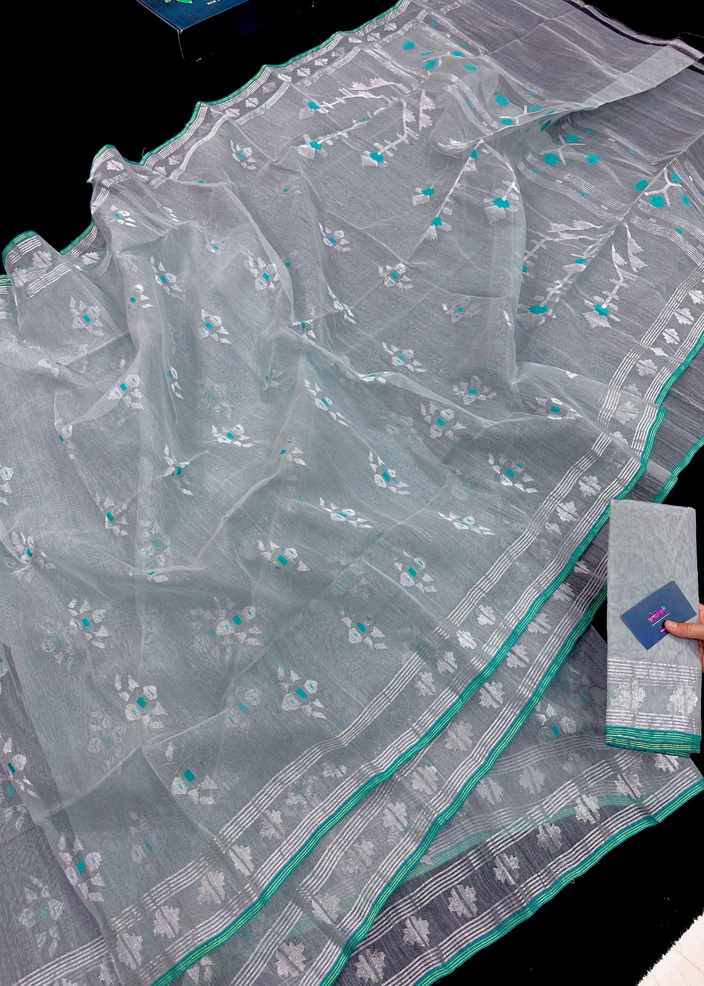 Silvery jamdani saree with silver jori work and green threads work.