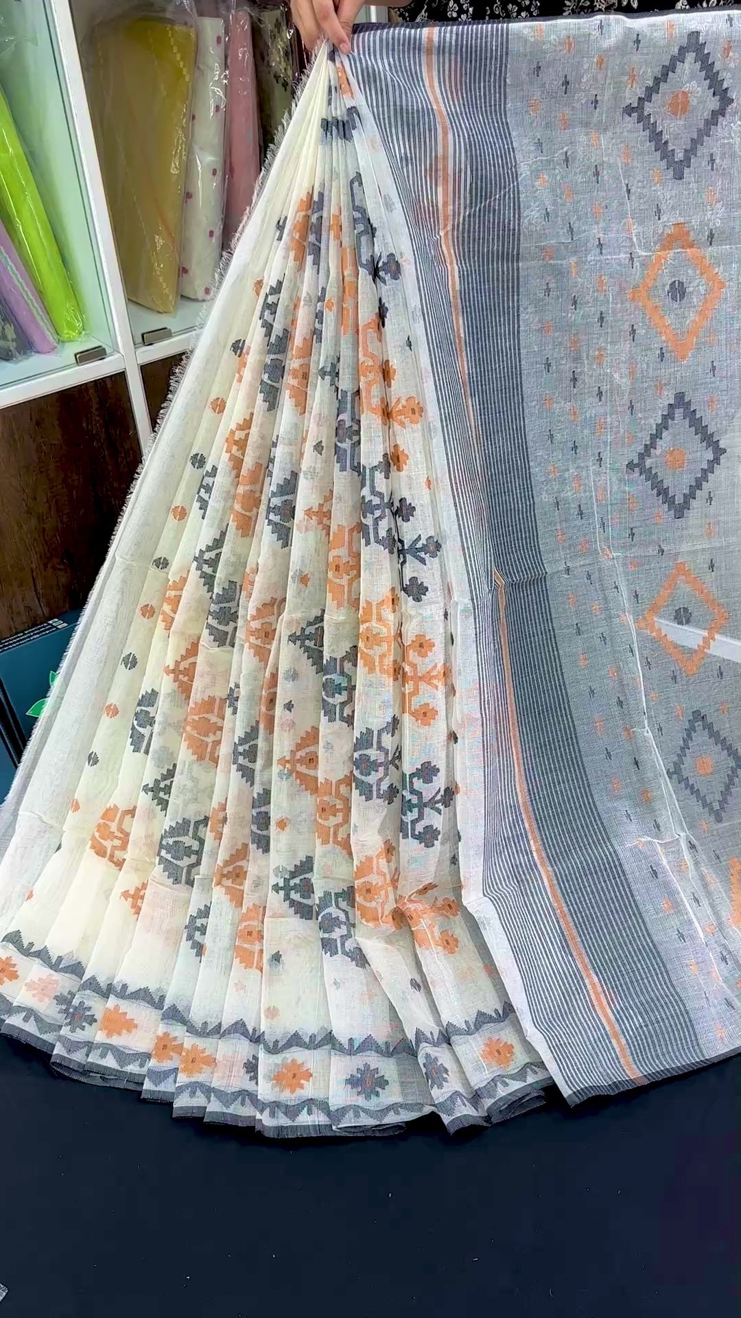 White cotton jamdani saree with orange black floral threads work