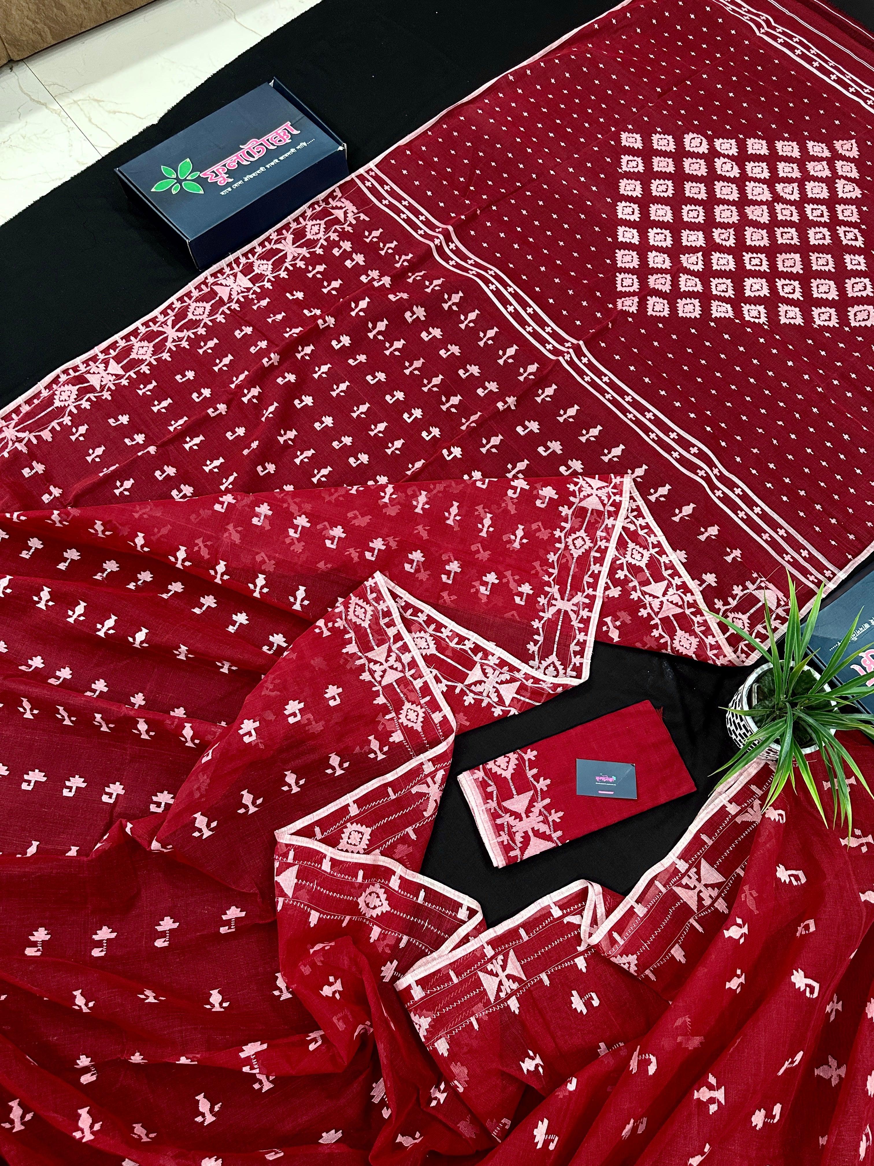 Maroon jamdani saree with white thread work.