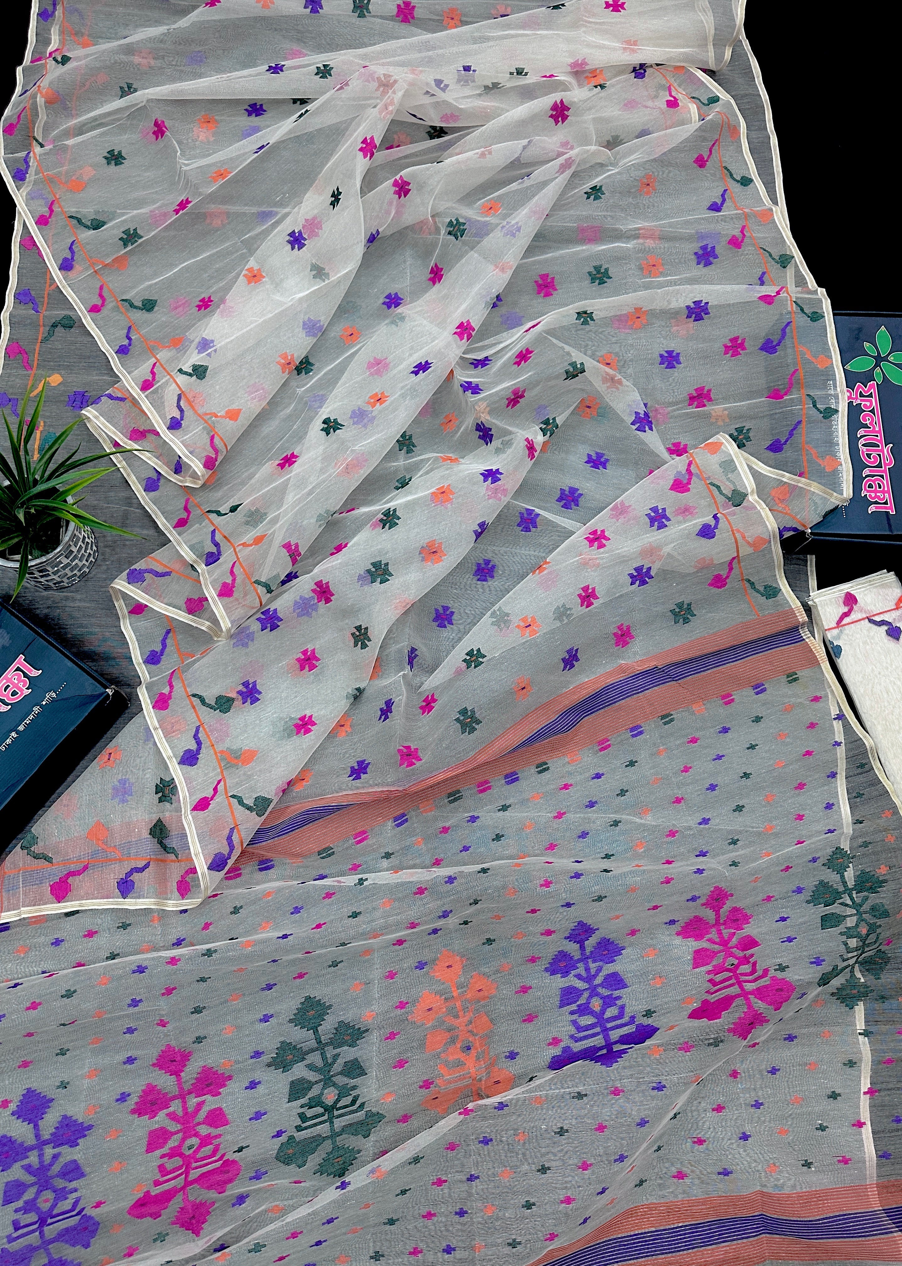 White jamdani saree with purple pink green orange threads work.