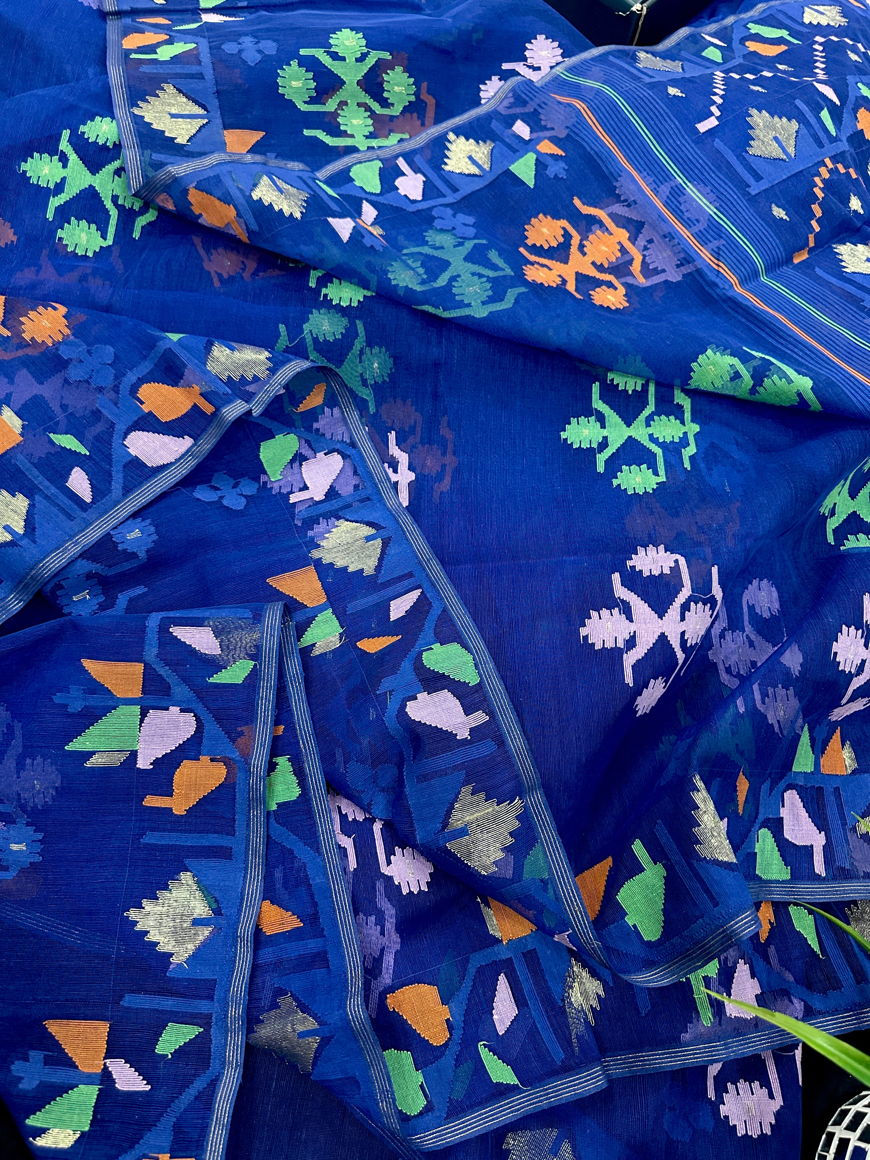 Royal blue jamdani saree with green pink blue orange threads work.
