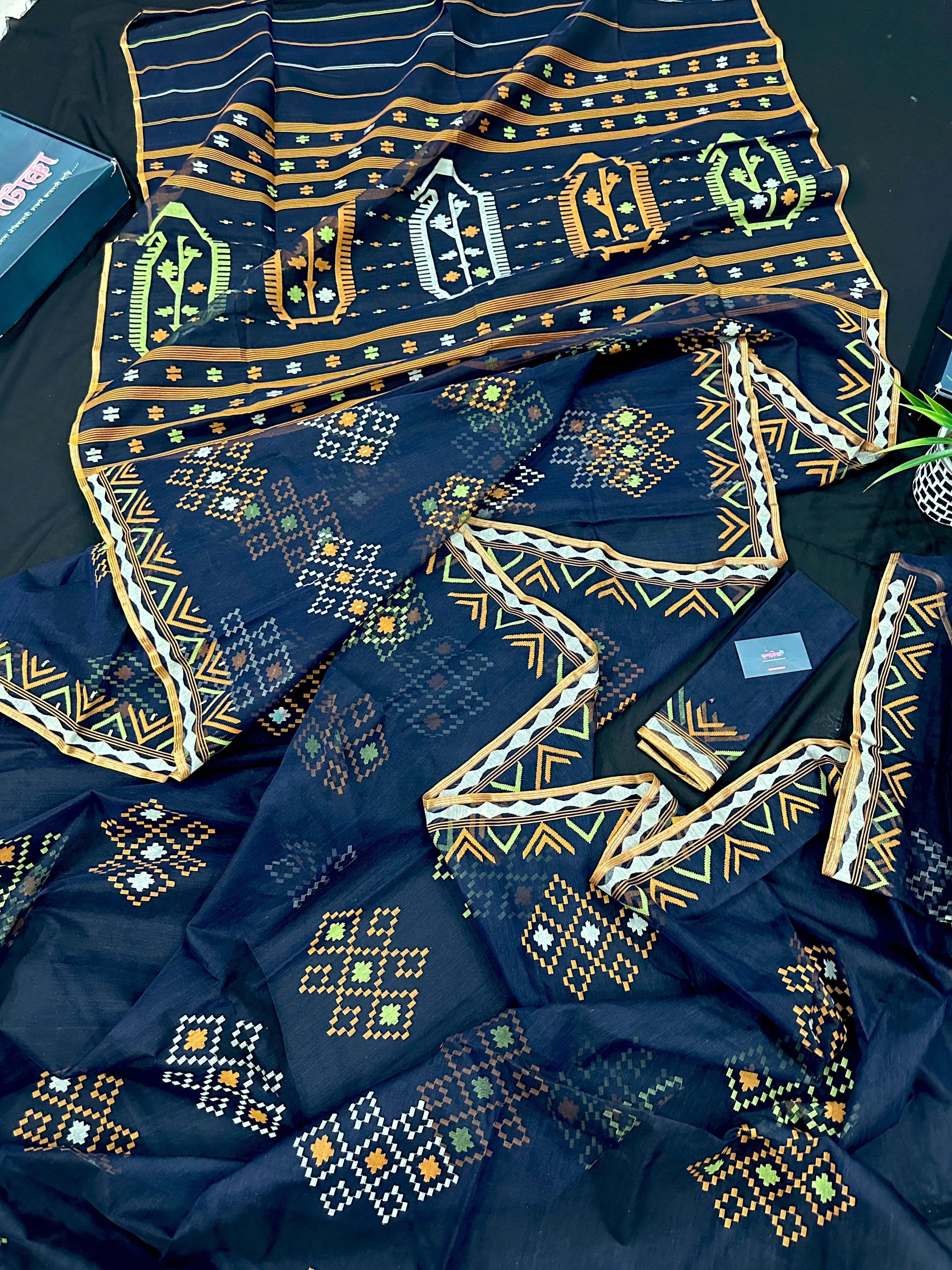 Navy blue jamdani saree with orange  green & off white threads work.