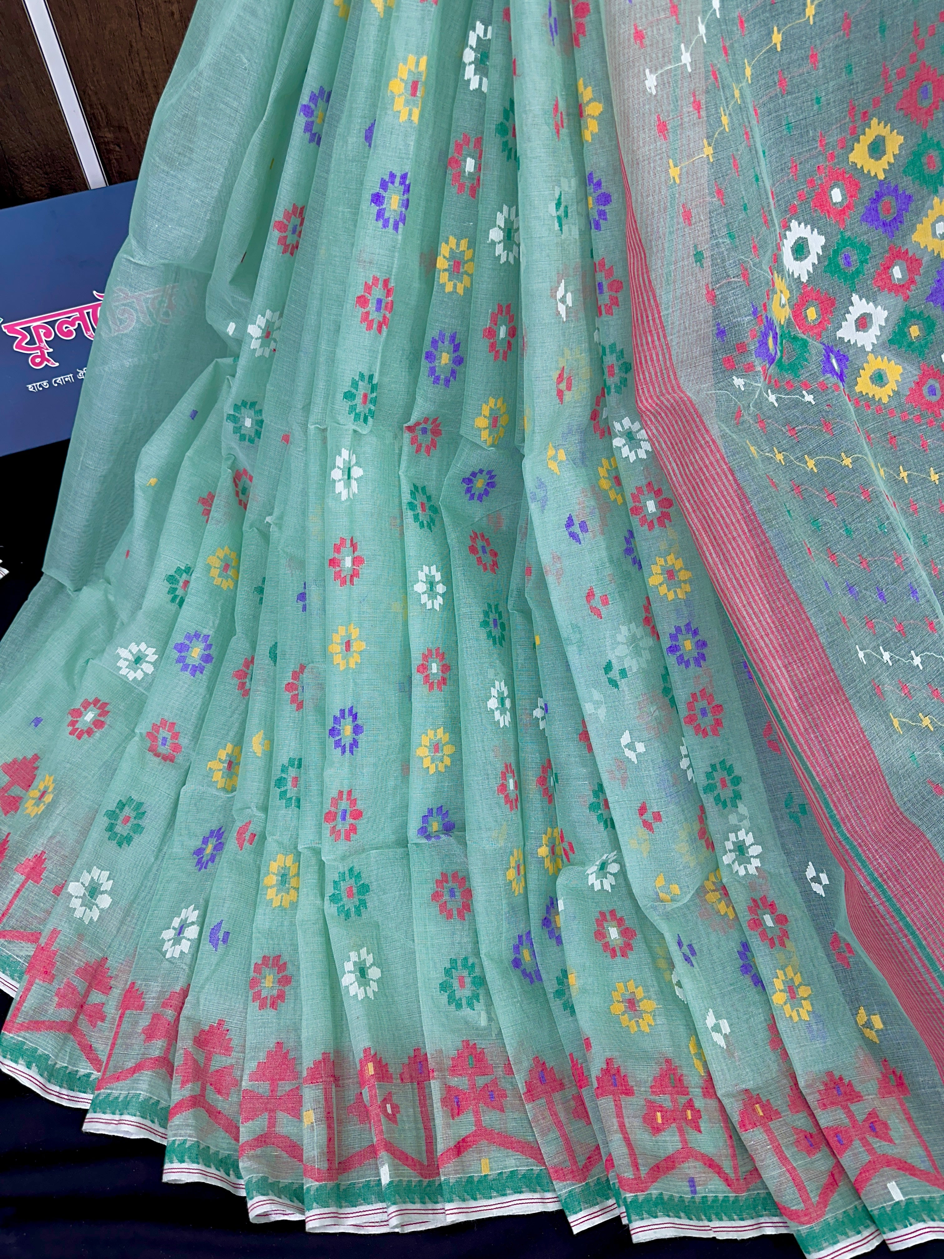 Mint cotton jamdani saree with yellow blue purple red white floral work.