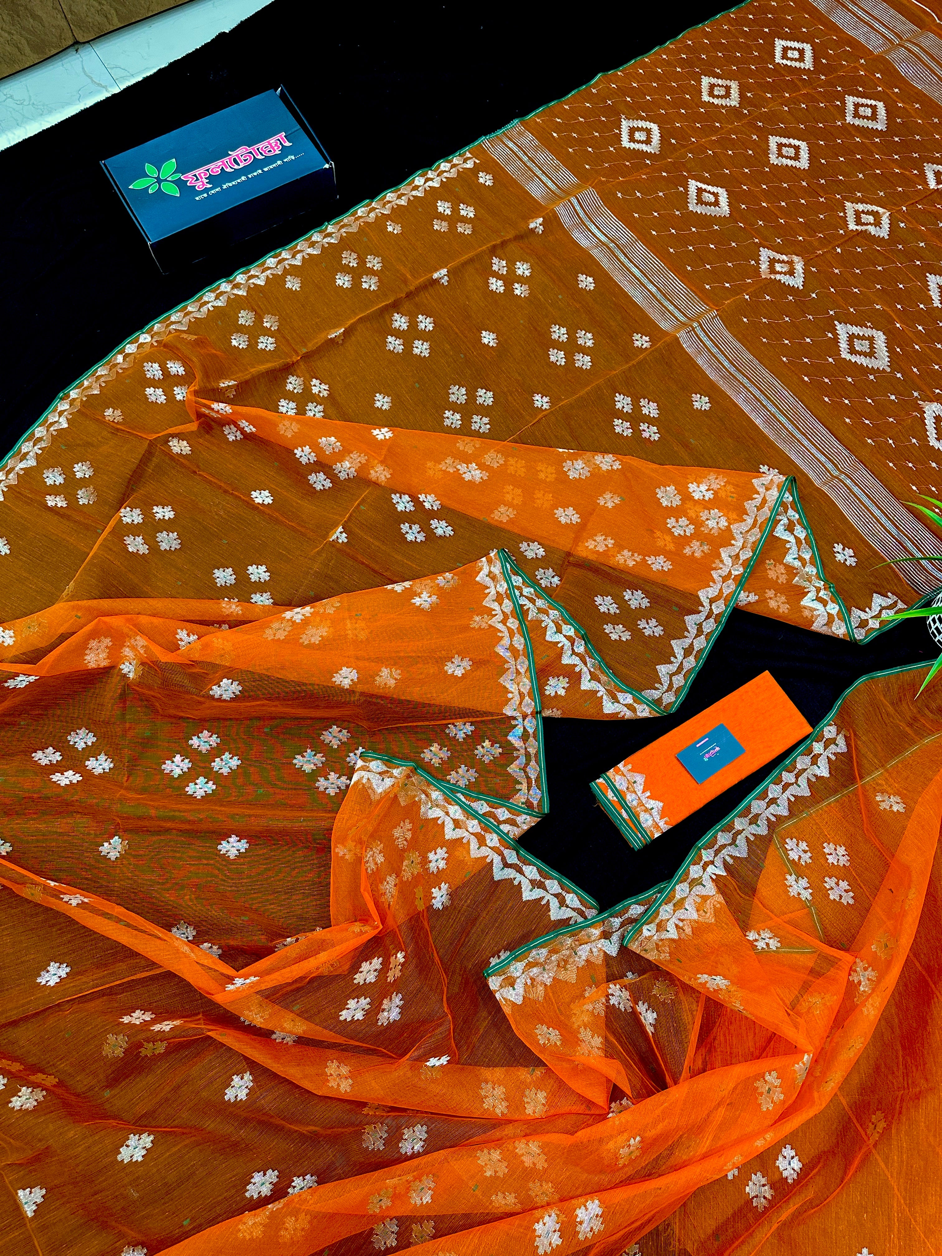 Orange soft jamdani saree with silver jori work & green border.