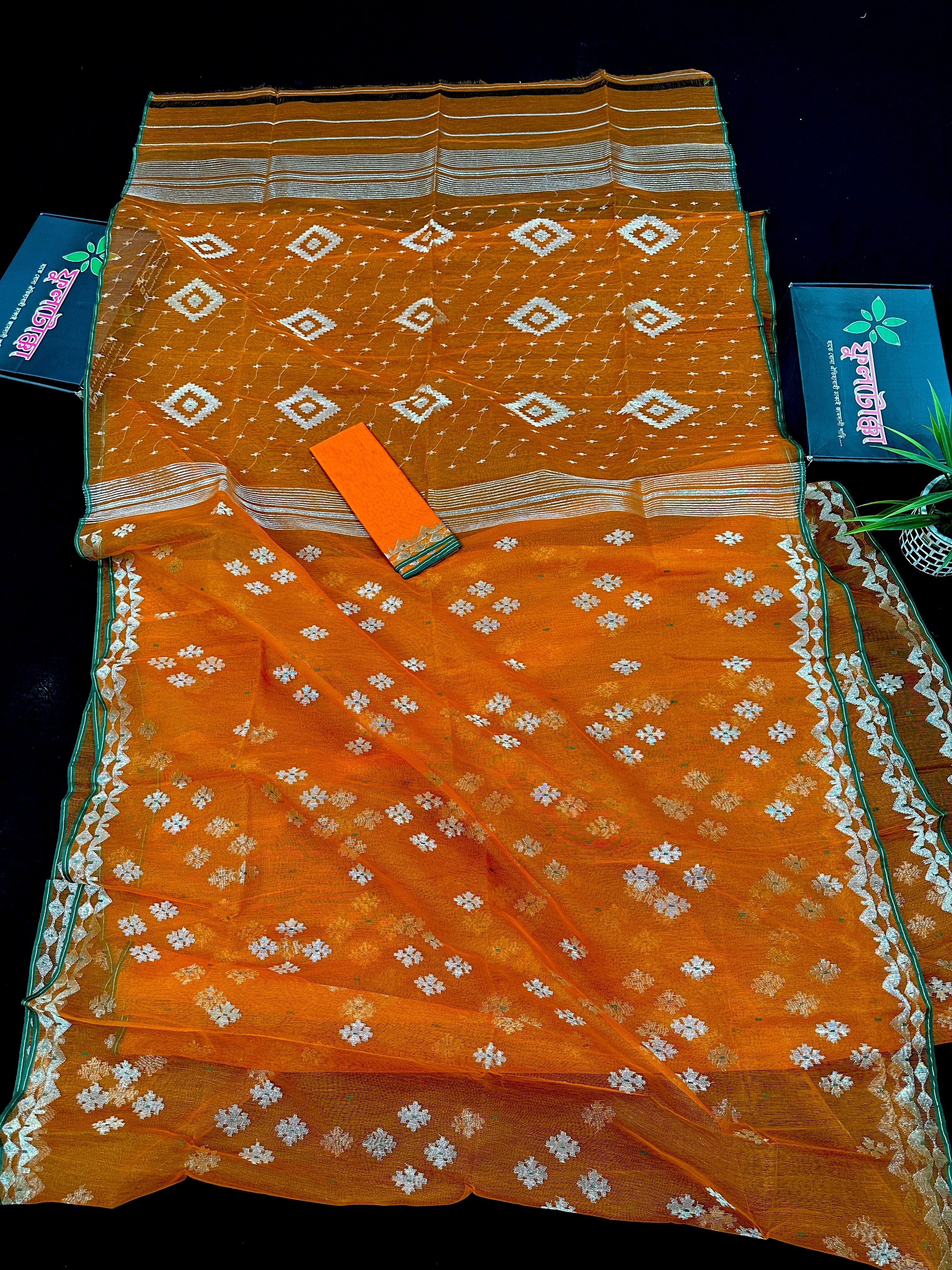 Orange soft jamdani saree with silver jori work & green border.
