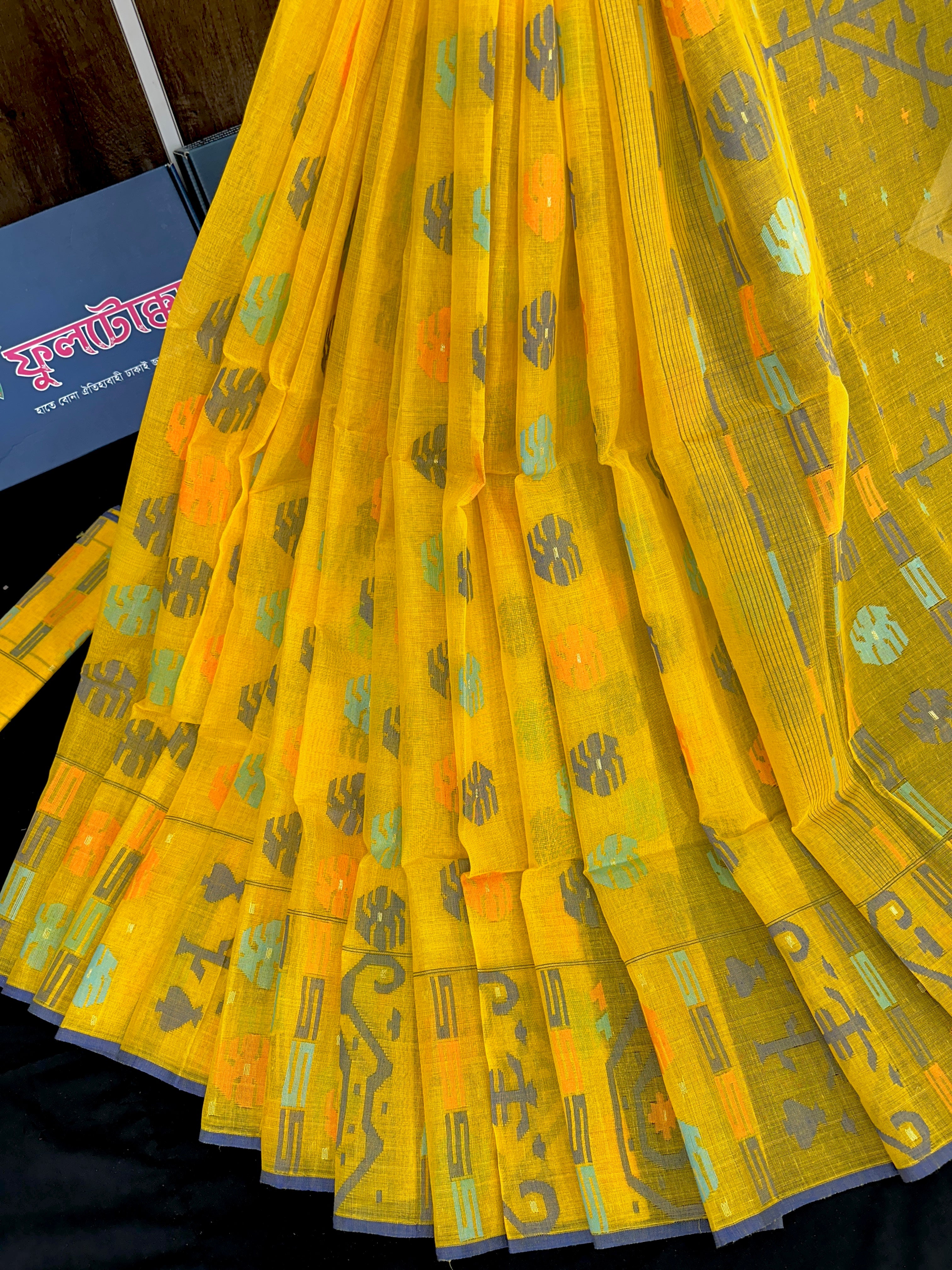 Yellow cotton jamdani saree with orange grey green blue colour threads work.