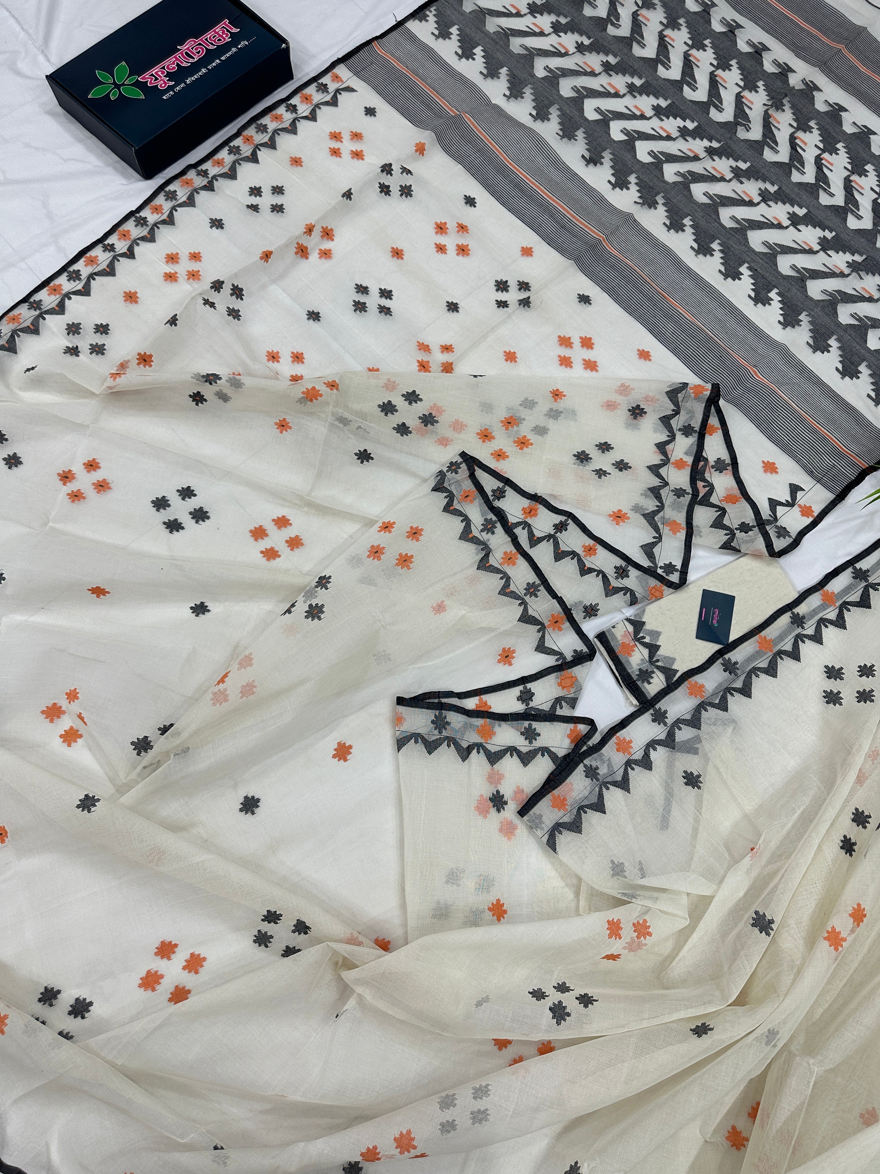 White cotton jamdani saree with orange & black threads work.