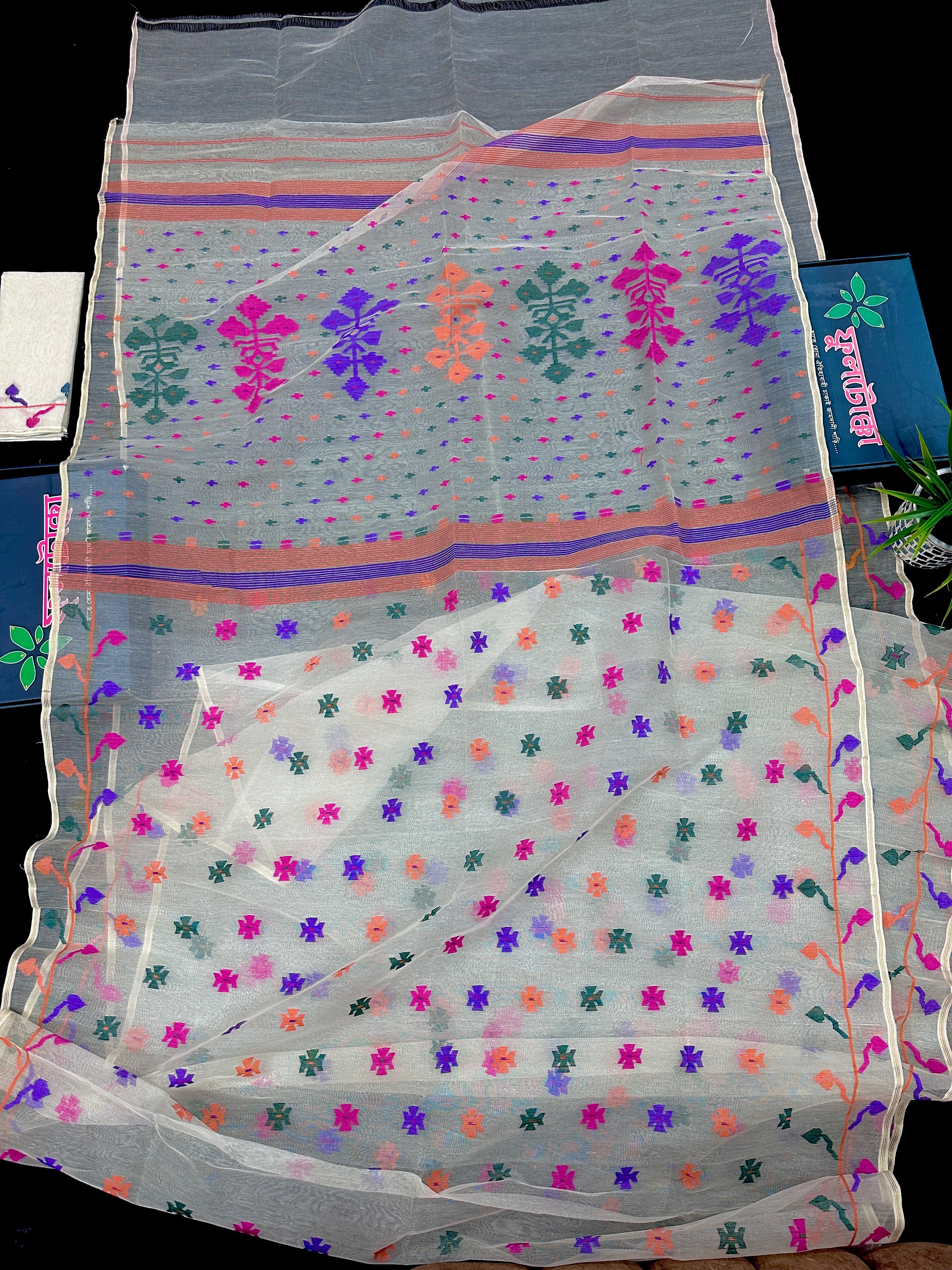 White jamdani saree with purple pink green orange threads work.
