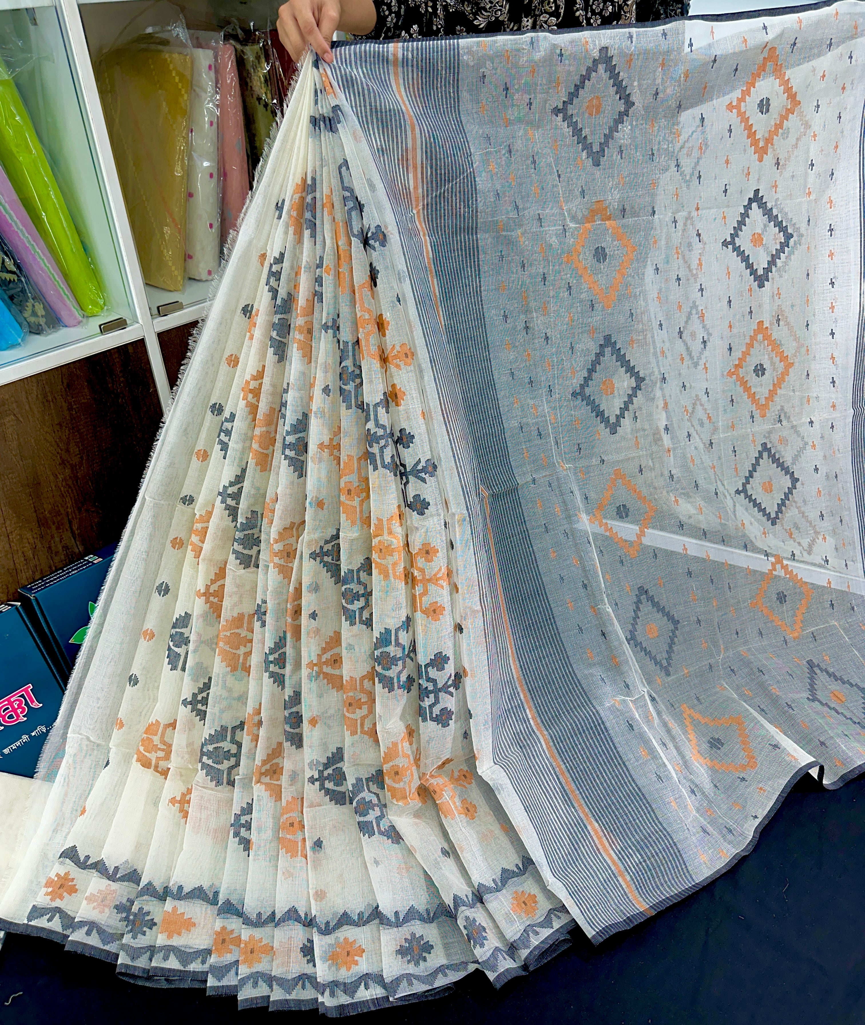 White cotton jamdani saree with orange black floral threads work
