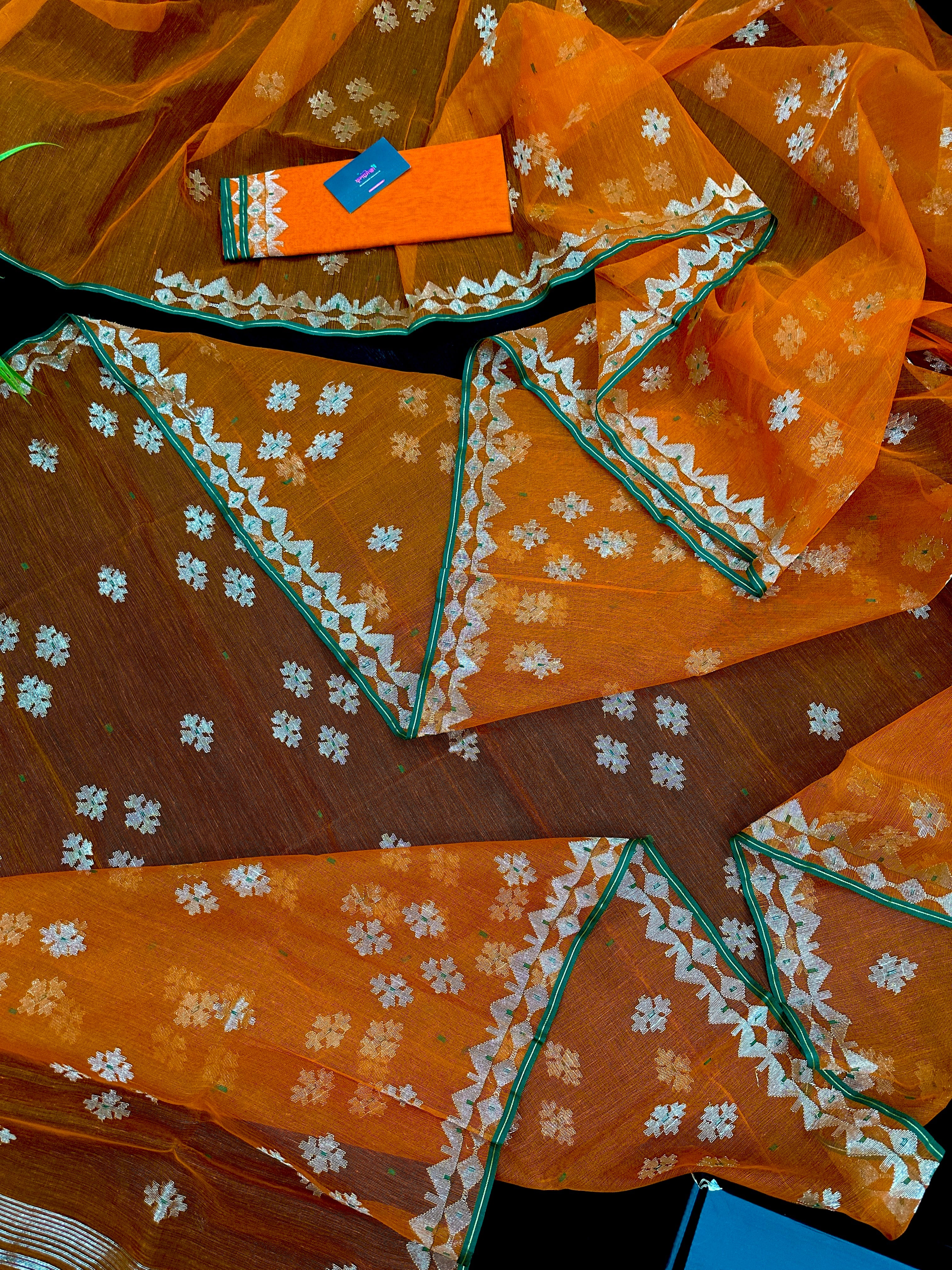Orange soft jamdani saree with silver jori work & green border.