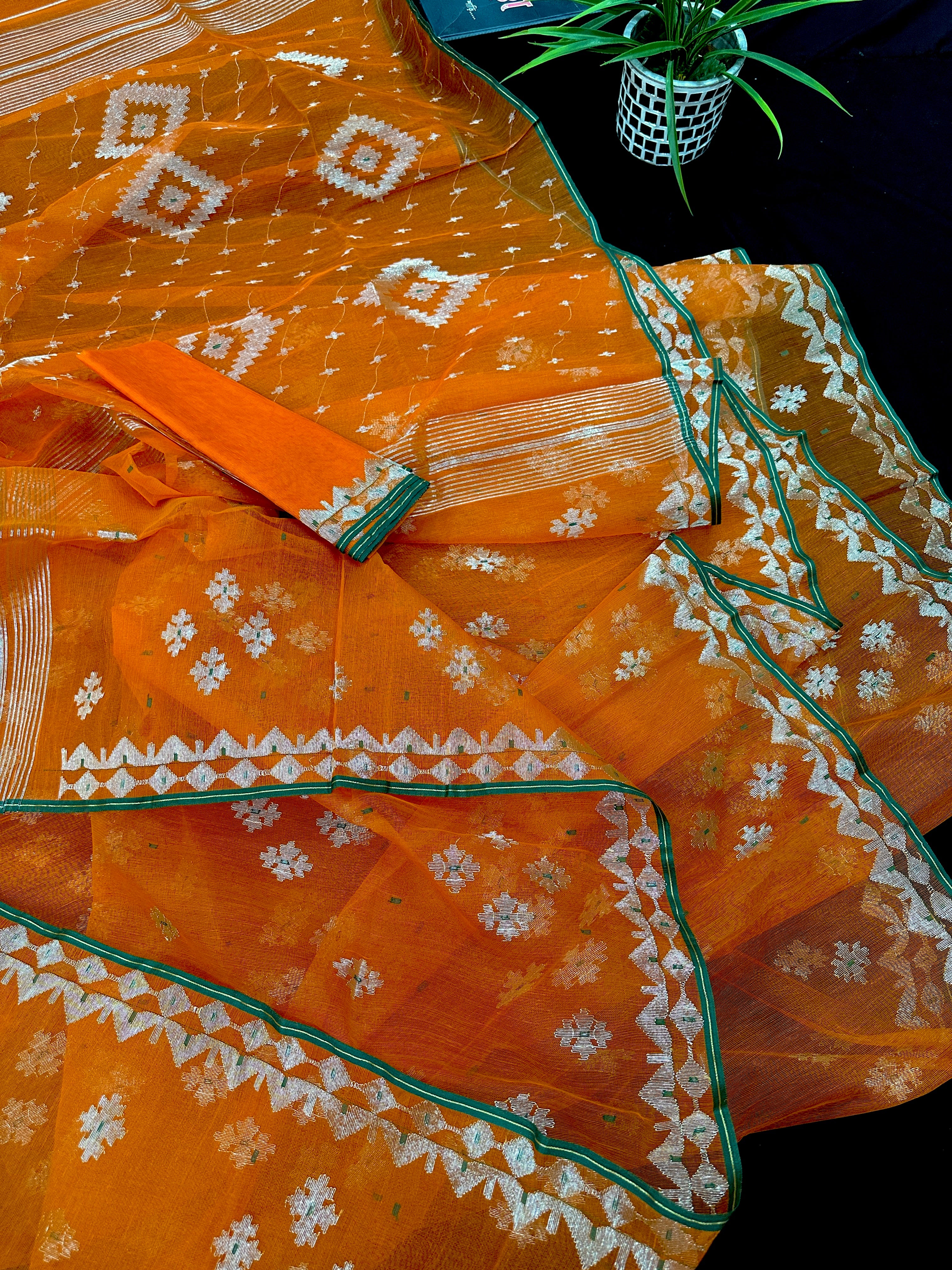 Orange soft jamdani saree with silver jori work & green border.