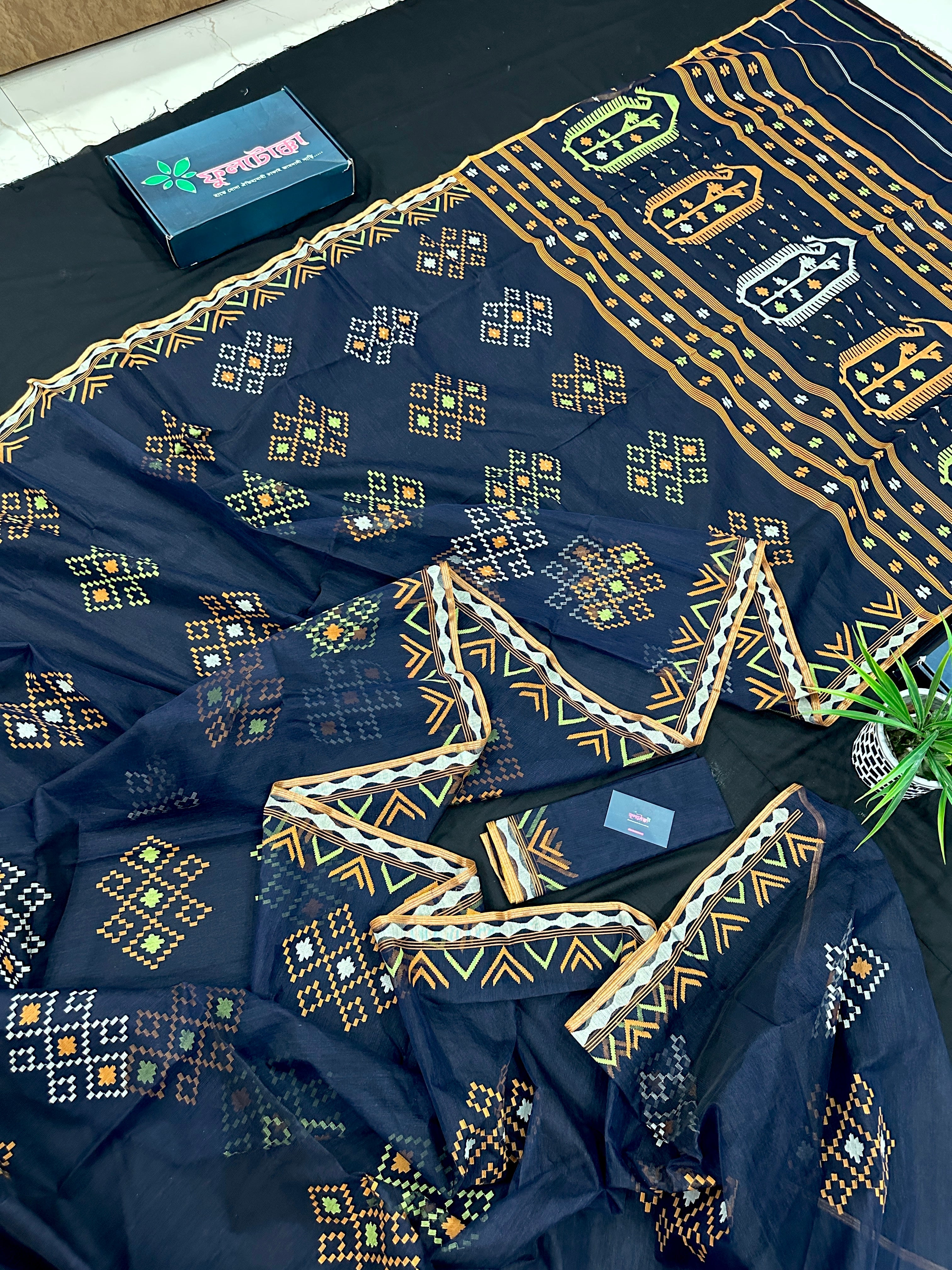 Navy blue jamdani saree with orange  green & off white threads work.