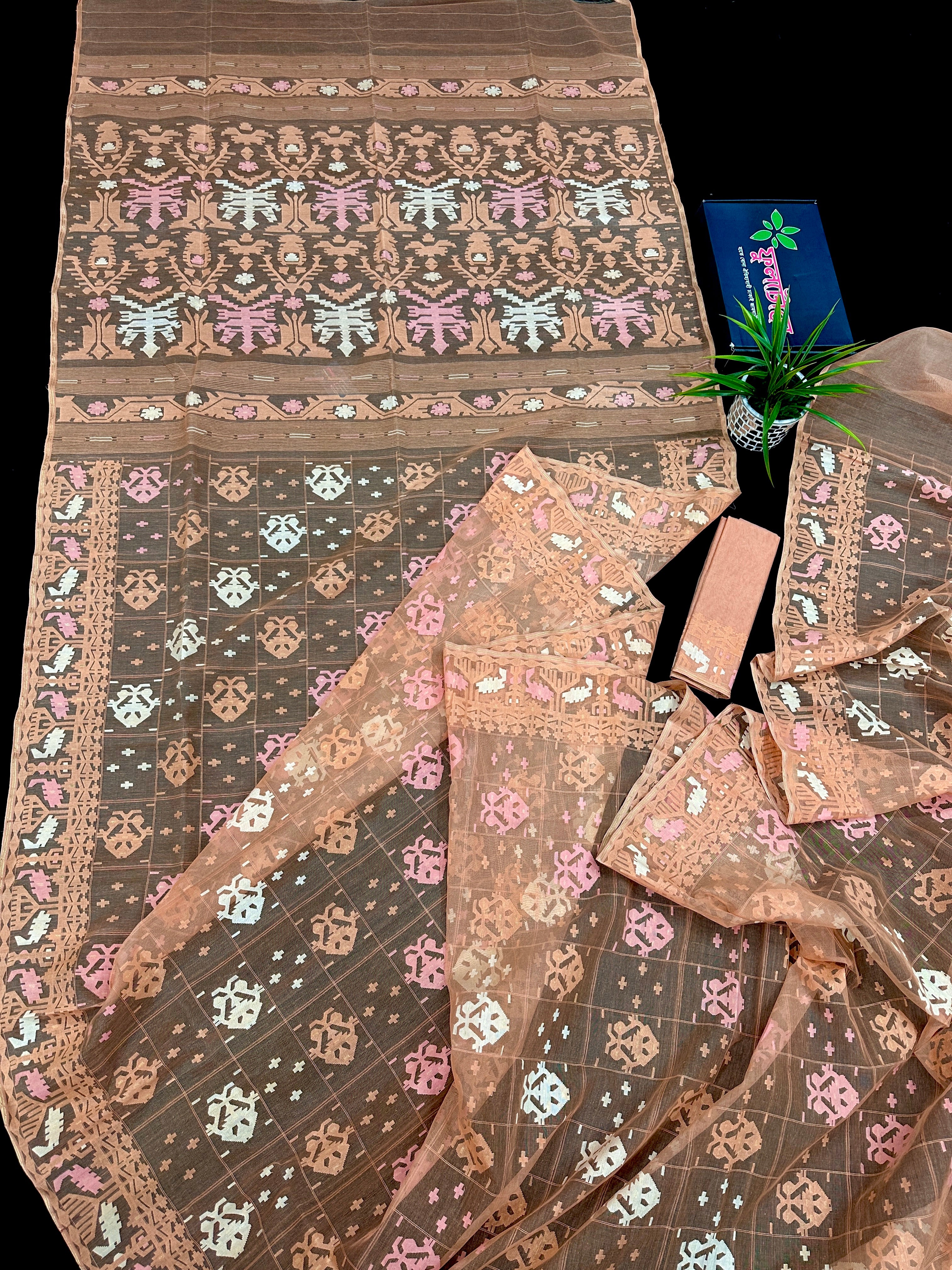 Creamy peach jamdani saree with pink white and peach threads work.