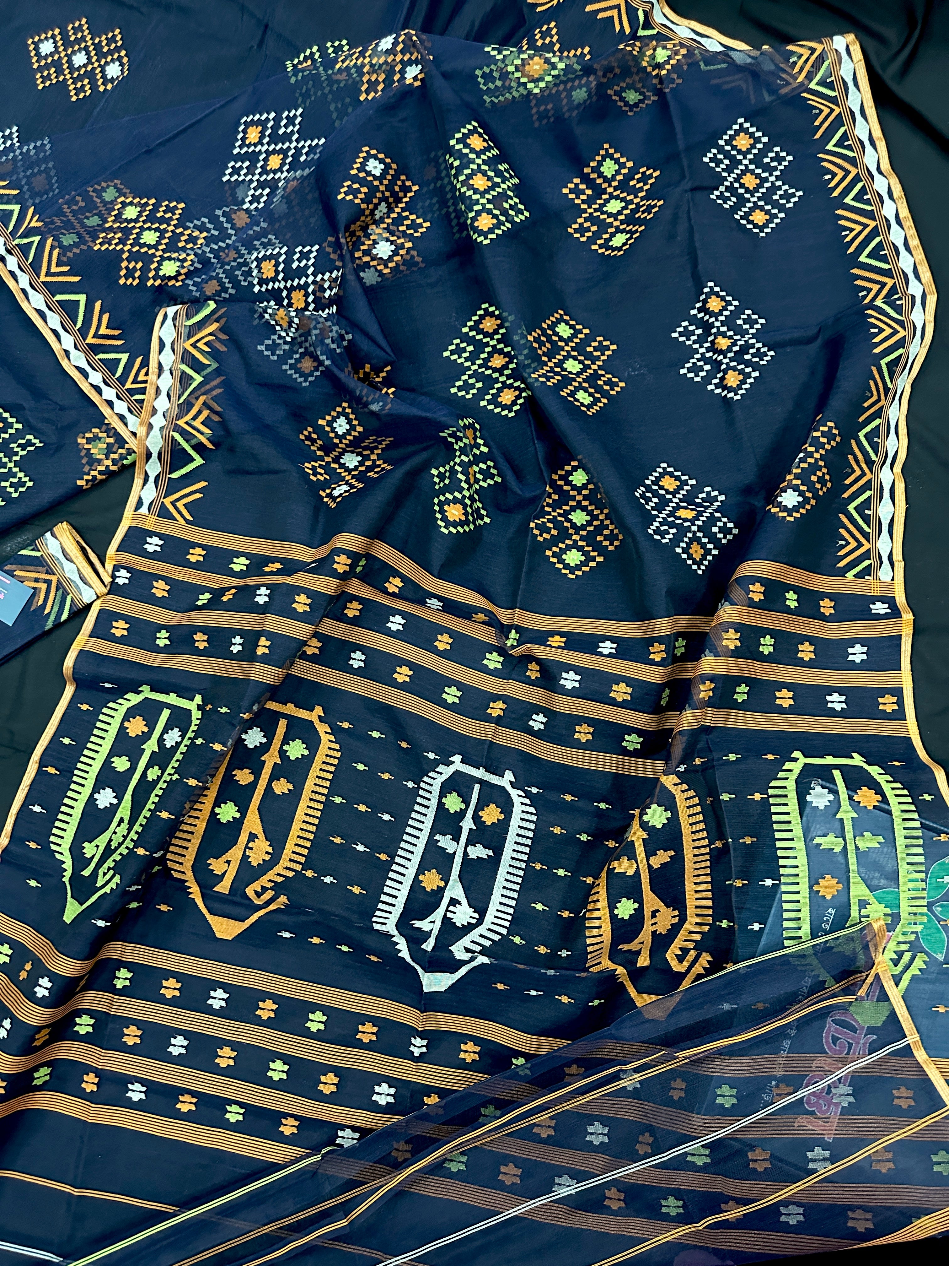Navy blue jamdani saree with orange  green & off white threads work.