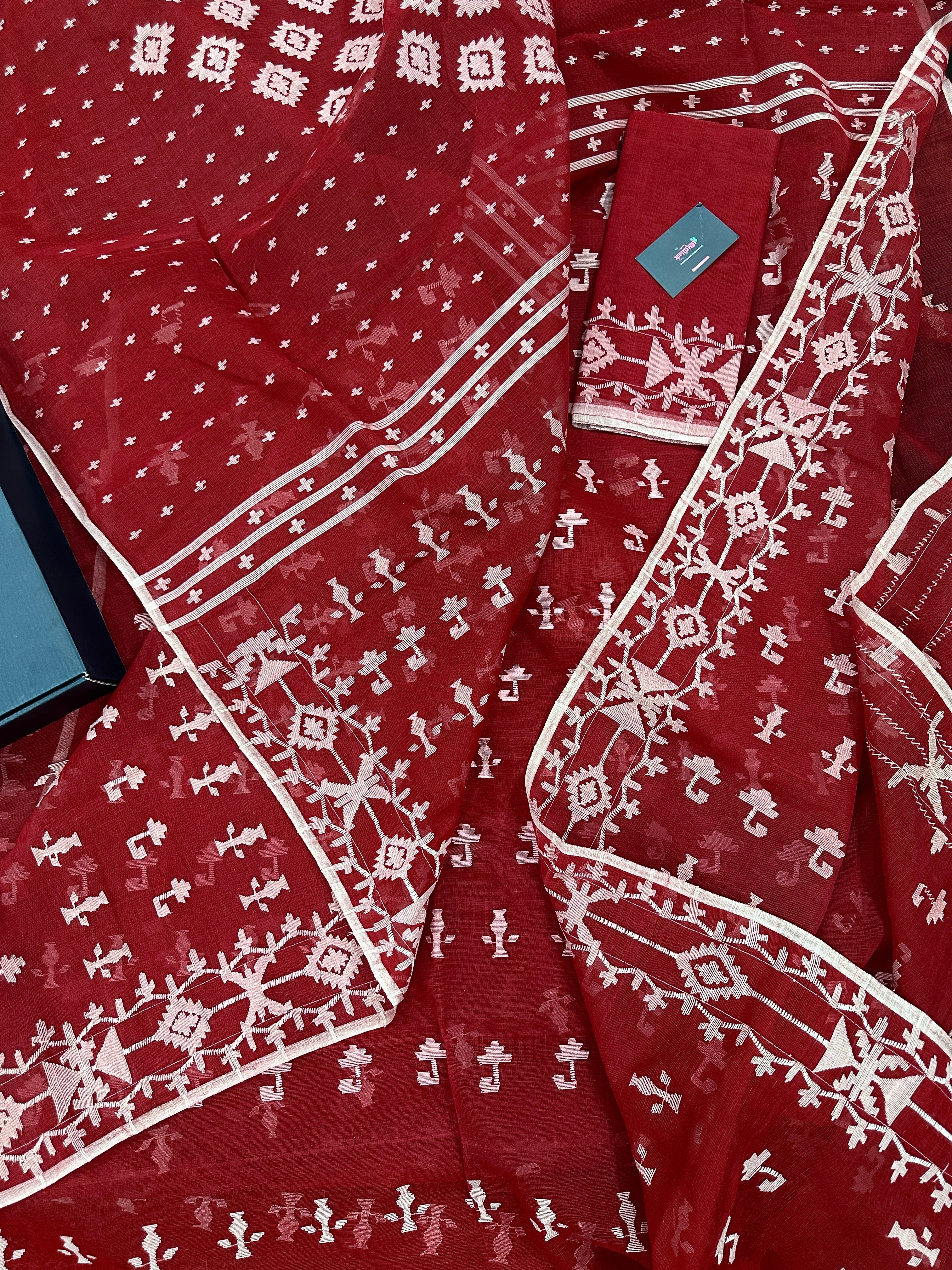 Maroon jamdani saree with white thread work.